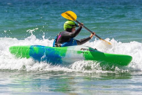 a man is in a kayak in the water at Ty Pren Bach in Maenclochog