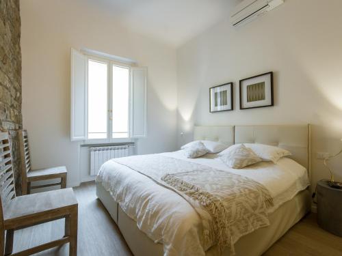 フィレンツェにあるMamo Florence - San Firenze Luxury Apartmentの白いベッドルーム(大型ベッド1台、窓付)