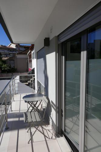 a table and a chair on a balcony at Two Churches Apartment in Leiria