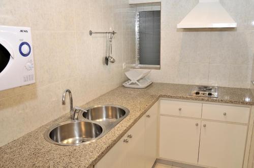 eine Küchentheke mit einem Waschbecken und einem Spiegel in der Unterkunft Apartaments Turistics Pirineu in Soldeu