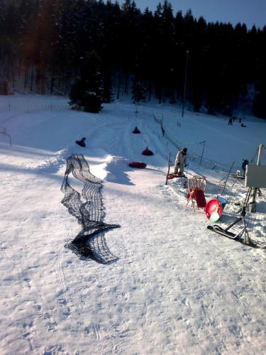 a person sitting in the snow on a ski slope at Chata Adavy in Liptovský Ján
