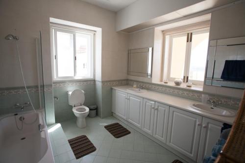 a bathroom with a toilet and a sink and a mirror at Villa Bernardette in Xagħra