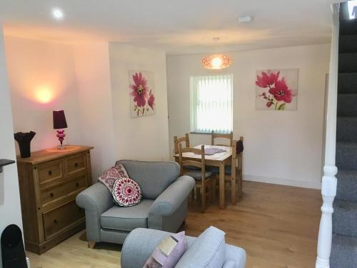 - un salon avec un canapé, une chaise et une table dans l'établissement Snowdon Cottage, à Caernarfon