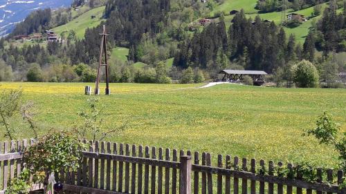 a fence in a field with a field of flowers at Gästehaus Pfister Maria in Hippach