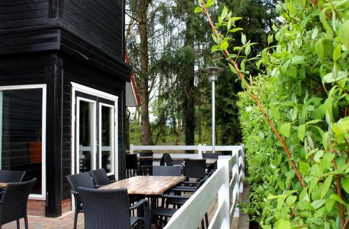 a patio with a wooden table and chairs at B&B "de Wingerd" in Bruchterveld