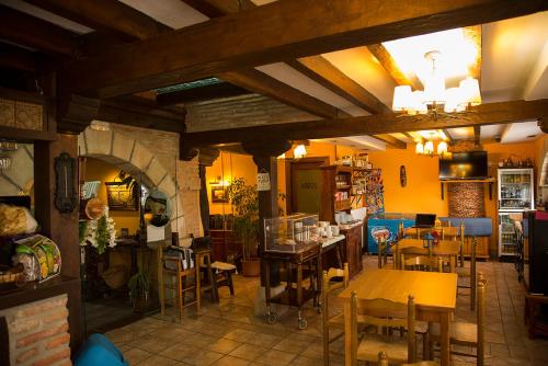 a restaurant with tables and chairs in a room at Trisileja en Puente Romano in Toñanes