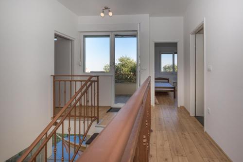 a hallway with a staircase in a house with windows at Villa Mathilde in Ugljan