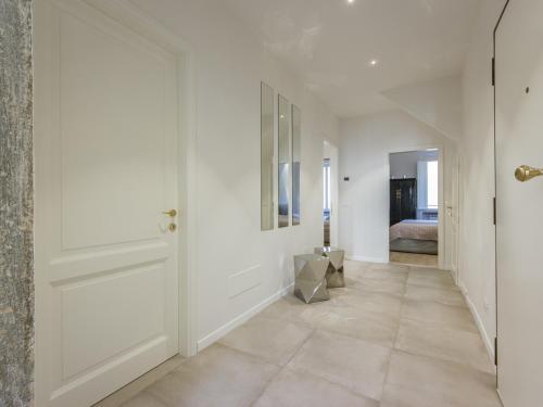 un pasillo con paredes blancas y una puerta blanca en San Firenze Luxury Apartment by Mamo Florence, en Florencia