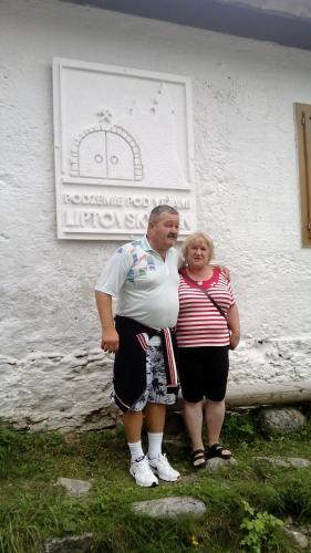 a man and a woman standing in front of a building at Chata Adavy in Liptovský Ján