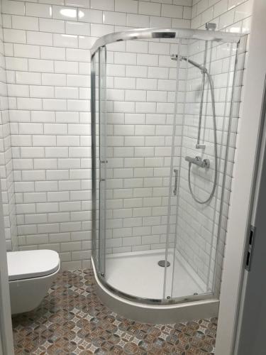 a shower stall in a bathroom with a toilet at Apartament Biały w Rewalu in Rewal