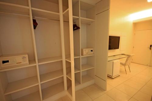 a room with shelves and a desk and a television at Hotel Jangadeiro in Recife