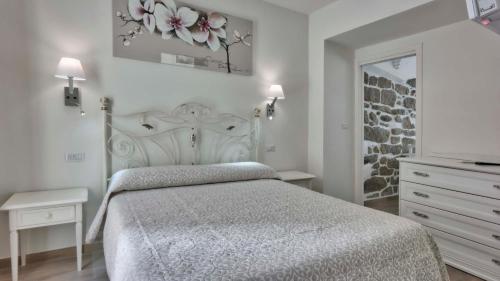a bedroom with a bed and a dresser and a mirror at Smart Suite & Apartments in Santa Teresa Gallura