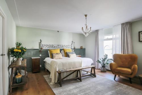 a bedroom with a bed and a chair at De Verwennerie in Zierikzee