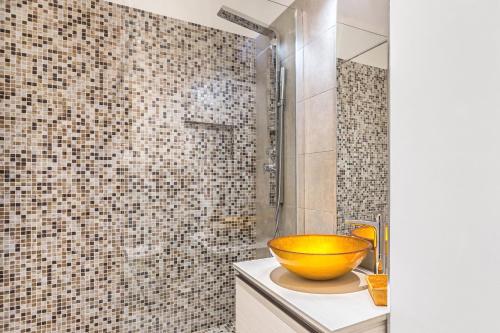 - une salle de bains avec un bol jaune sur un comptoir dans l'établissement Luxury Central Apartment, à Turin