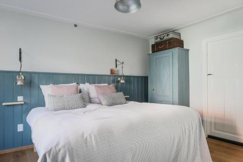a bedroom with a large white bed with pink pillows at De Verwennerie in Zierikzee