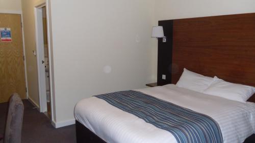 a bedroom with a large bed with a wooden headboard at Eyesleepover in Eyemouth