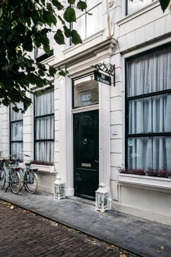 a black door on a white building with bikes parked outside at De Verwennerie in Zierikzee
