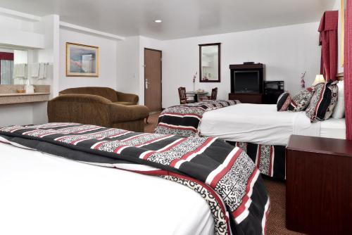 パサデナにあるAmericas Best Value Inn Pasadenaのベッド3台とリビングルームが備わるホテルルームです。