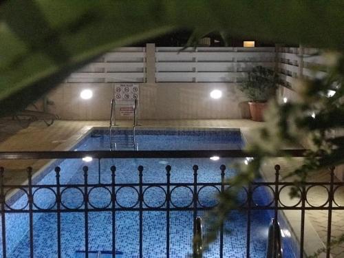 - une piscine entourée d'une clôture la nuit dans l'établissement Panais Villa, à Kiti