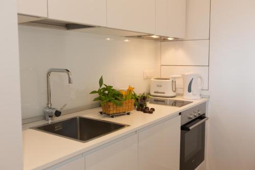 Una cocina con gabinetes blancos y un fregadero. en Salerno Prestige Apartment, en Salerno