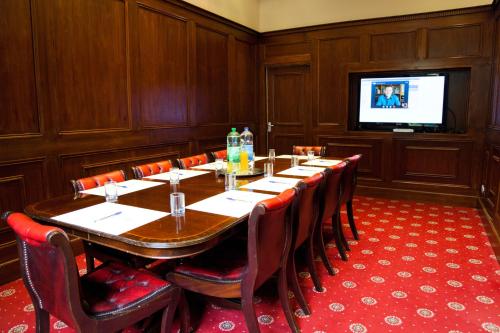 a conference room with a table and chairs and a television at Whiston Hall in Whiston