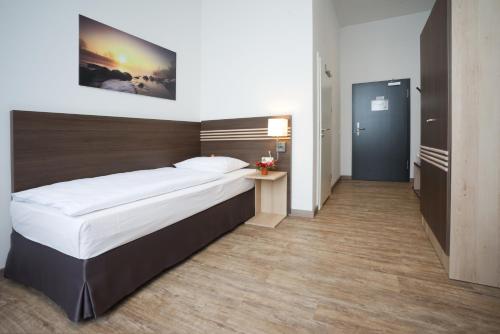 a bedroom with a large bed with a wooden headboard at Ruhr Inn Hotel in Hattingen