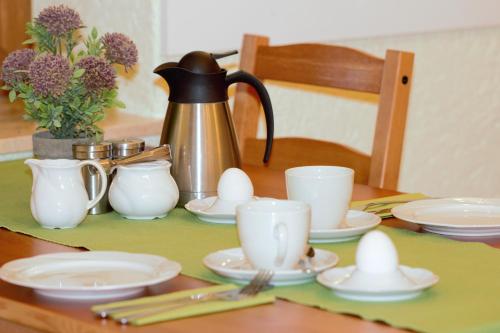 a table with a tea kettle and eggs on it at Pension Ujut in Bad Langensalza