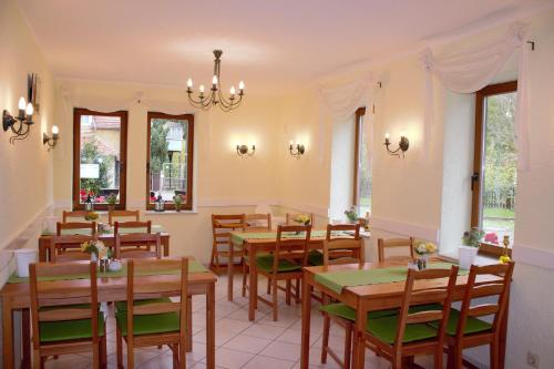 a dining room with wooden tables and chairs at Pension Ujut in Bad Langensalza