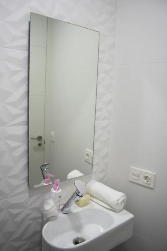 ein Badezimmer mit einem Waschbecken und einem großen Spiegel in der Unterkunft Smart Tech Plaza Studio in Salamanca