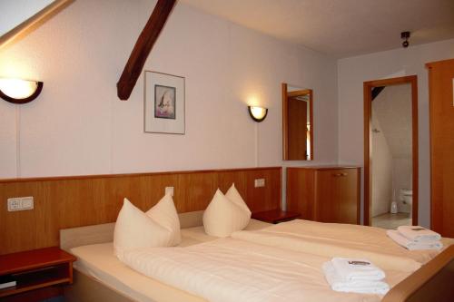 a bedroom with a large bed with white pillows at Pension Ujut in Bad Langensalza