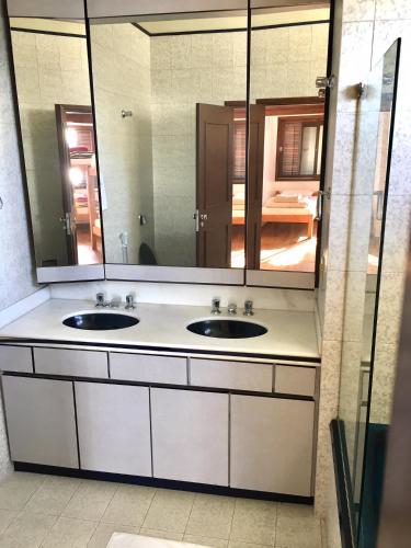 a bathroom with two sinks and a large mirror at Hostel Berghaus in Florianópolis