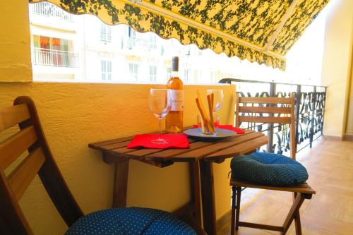 - une table avec un verre de vin et 2 chaises dans l'établissement Carré d’Or Appt 4 Pièces moderne et spacieux, à Nice