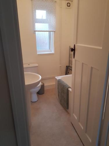 a bathroom with a tub and a sink and a toilet at Braganza House in Portsmouth