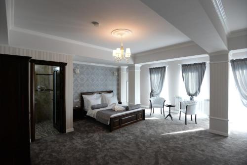 a bedroom with a bed and a table and chairs at The Classic in Buzău