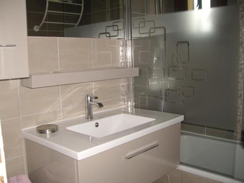 a white bathroom with a sink and a shower at Chalet Amandine in L'Alpe-d'Huez