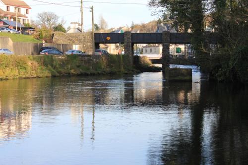 a river with a bridge and cars on it at The Bridges Bed and Breakfast in Donegal
