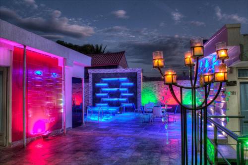 a patio with colorful lights on a building at night at Hotel Boutique El Poblado in Neiva