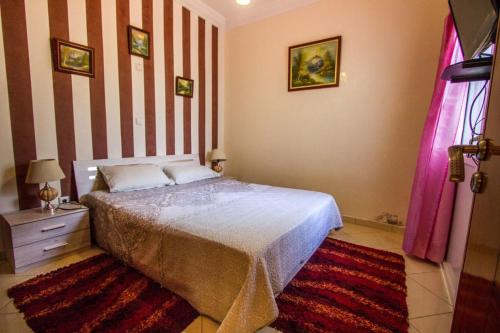 a bedroom with a bed and a striped wall at Salam Appartement Agadir in Agadir