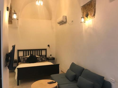 a living room with a bed and a couch at Acre Two Wells Zimmer in ‘Akko