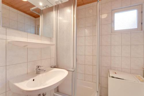 a white bathroom with a sink and a shower at Schwedenhaus-Seeblick-Useriner-See in Userin