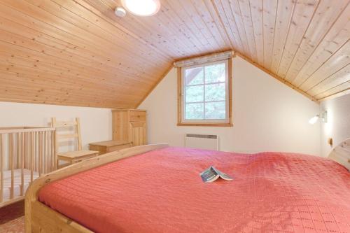 a bedroom with a large bed with a red blanket at Haus-am-See in Userin