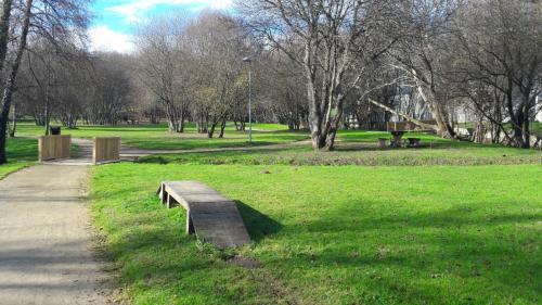 a park with a wooden bench in the grass at Albergue Camiño Real in Sigüeiro