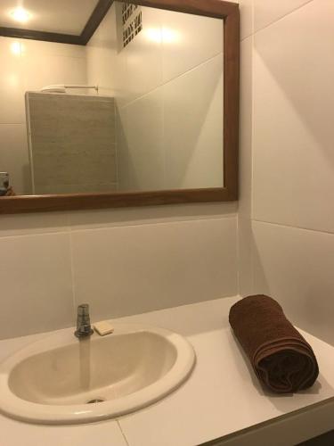 a bathroom sink with a mirror and a towel at Hotel & Bar La Guitarra in El Sunzal
