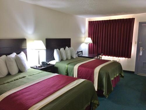 a hotel room with two beds with colorful blankets at Travel Inn & Suites in Atlanta