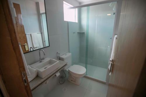 a bathroom with a sink and a toilet and a shower at Baía Branca Porto de Galinhas in Porto De Galinhas