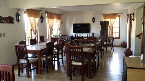 a dining room filled with wooden tables and chairs at Hostal Casa Amarilla San Vicente de Tagua Tagua in San Vicente de Taguatagua
