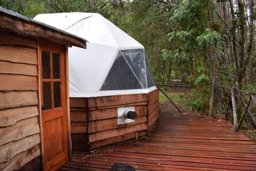 a cabin with a tent on a wooden deck at Vortice Chile Eco-Lodge in Manzanar