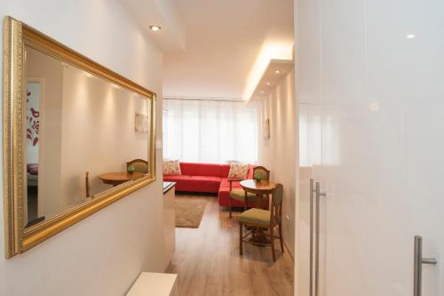 a living room with a red couch and a mirror at Ilona 2 bedrooms apartment in the center in Budapest