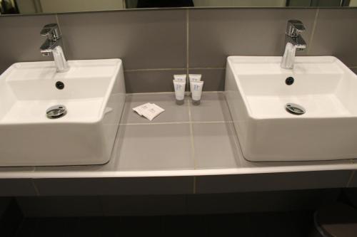 two white sinks on a counter in a bathroom at Galaxy Hotel in Athens