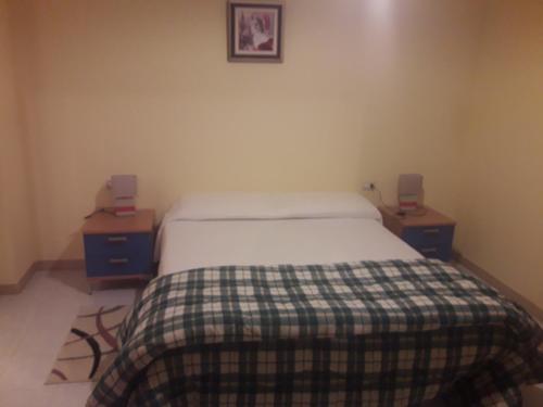 オルビアにあるWelcome Houseのベッドルーム1室(ベッド1台、ナイトスタンド2台、テーブル2台付)